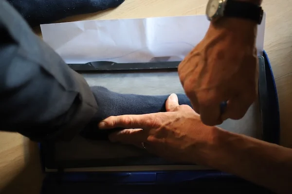 Artisan measuring a customer’s foot for bespoke shoes
