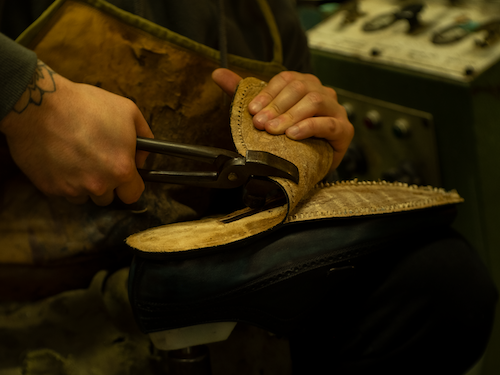 Traditional repair of a handcrafted leather shoe in the artisanal workshop